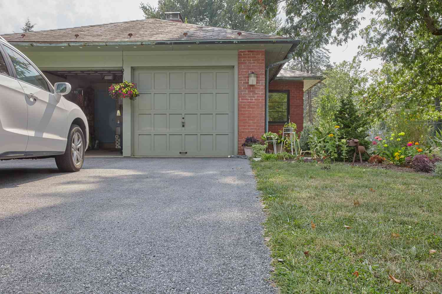 Pente de l'allée de la maison verte et en brique vérifiée pour savoir si elle cause un sous-sol humide