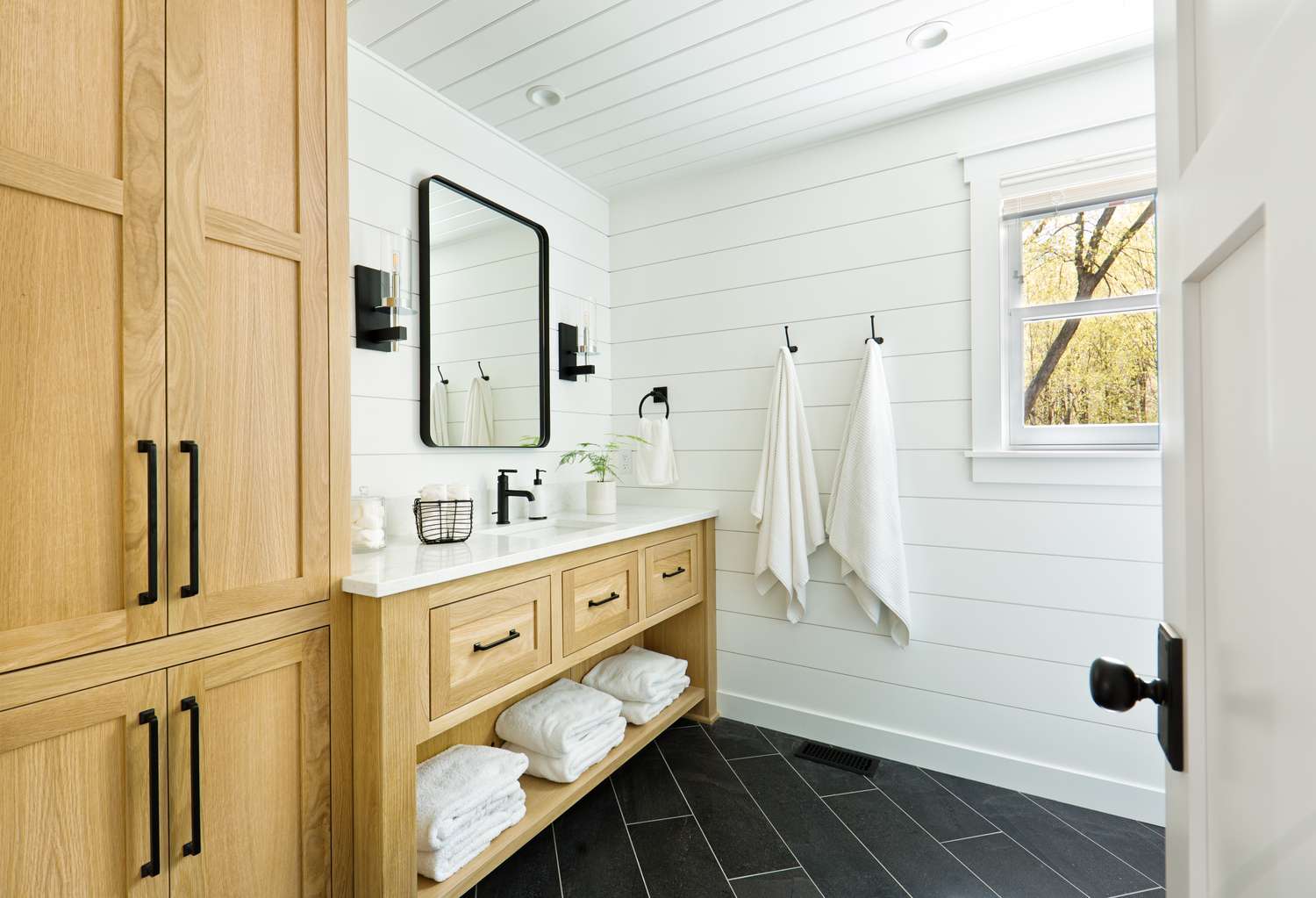 Salle de bain avec vanité en bois et murs en shiplap blanc