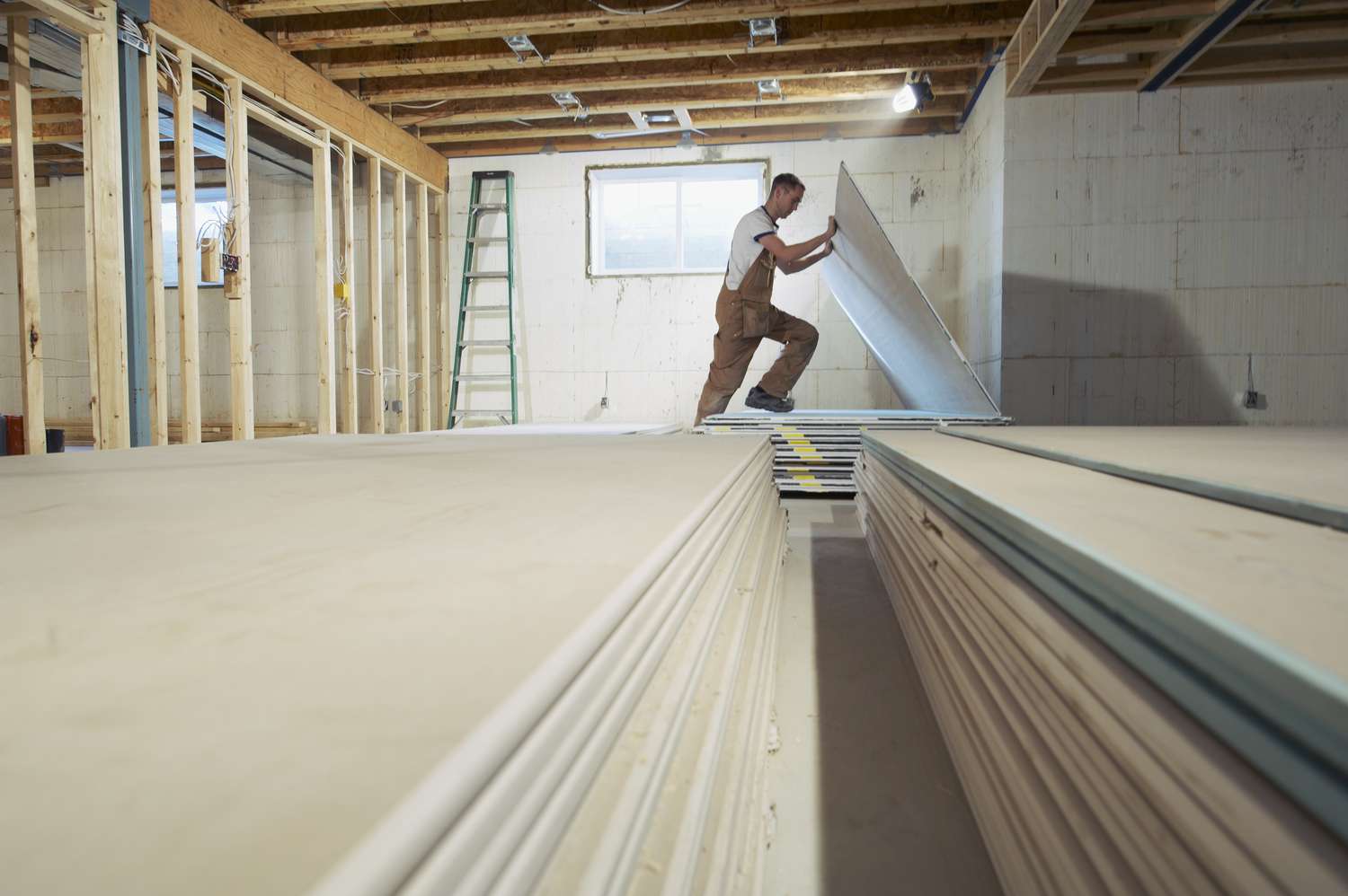 Homme installant du placoplâtre dans une nouvelle maison