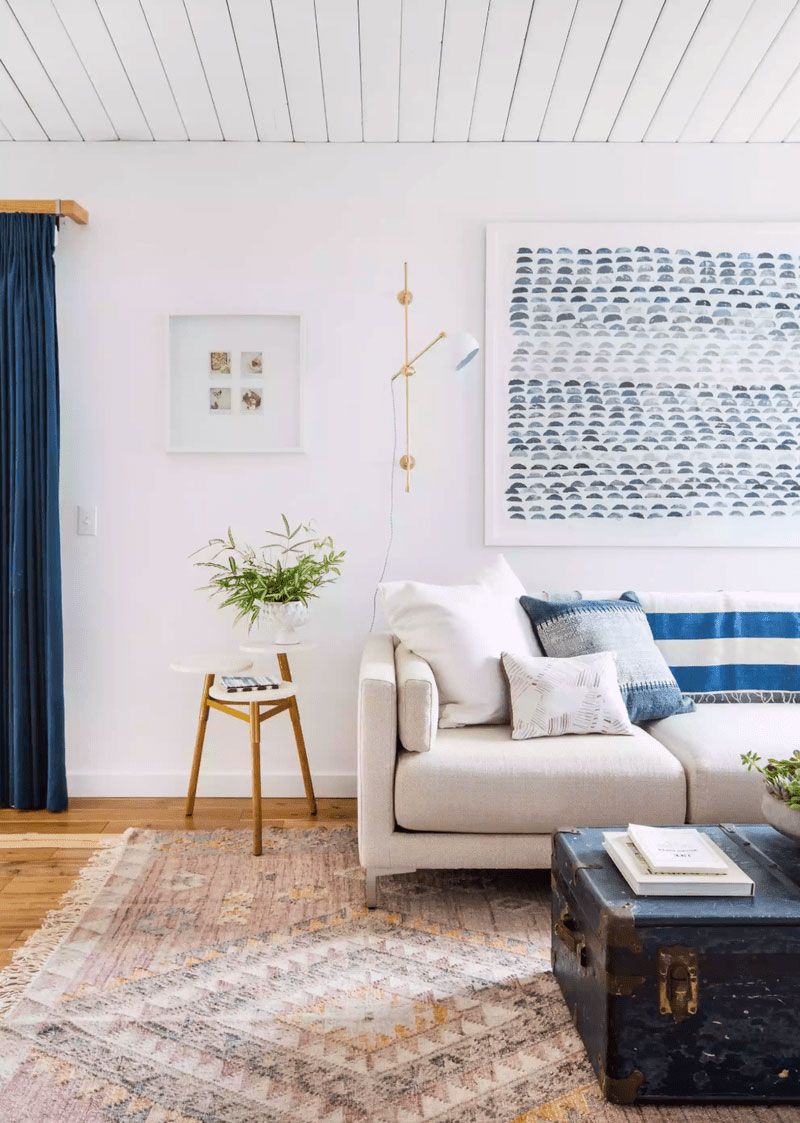 Living room with white-painted wood-paneled ceiling and blue accents throughout