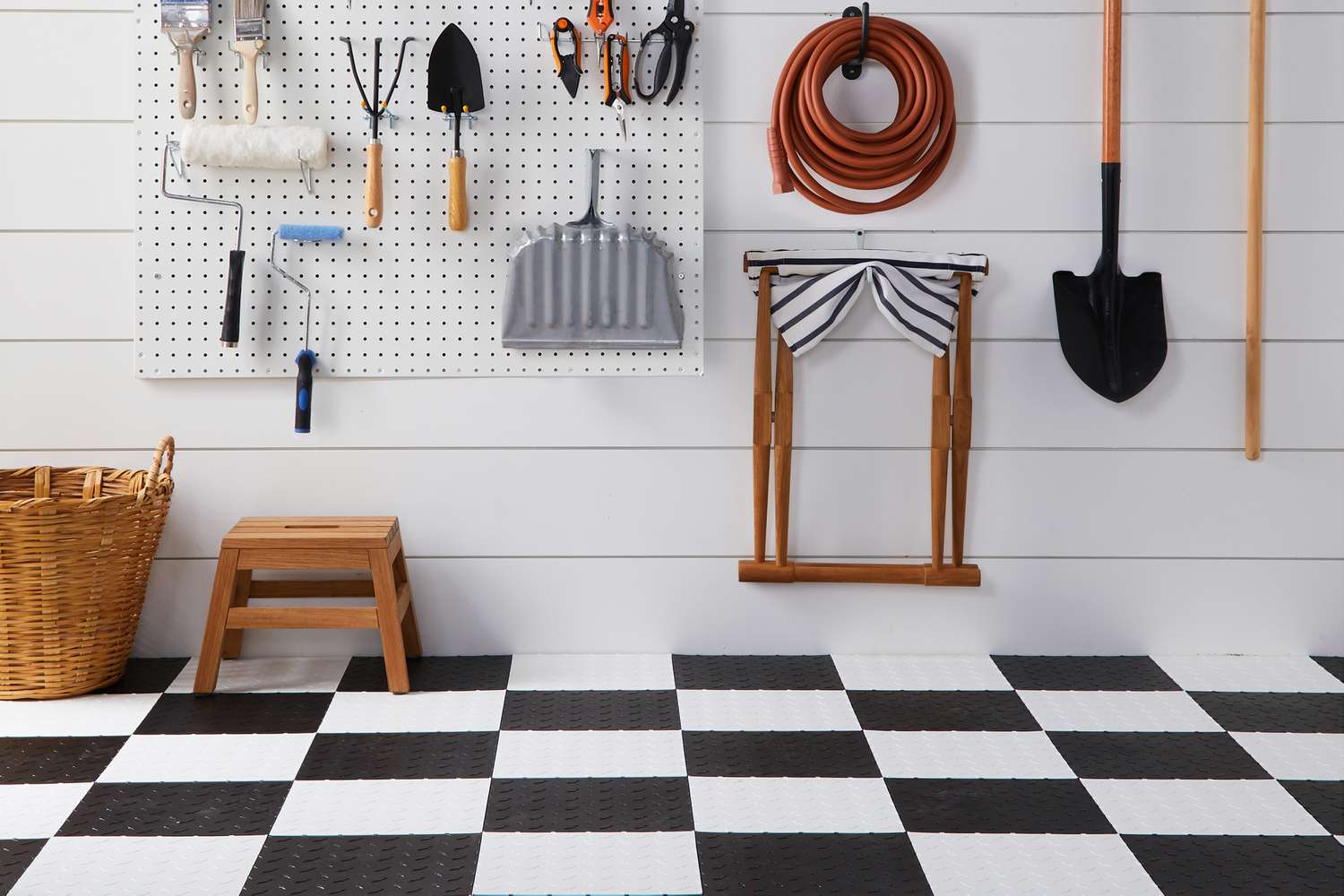 Mur de garage organisé avec des tuiles de sol en plastique rigide noir et blanc