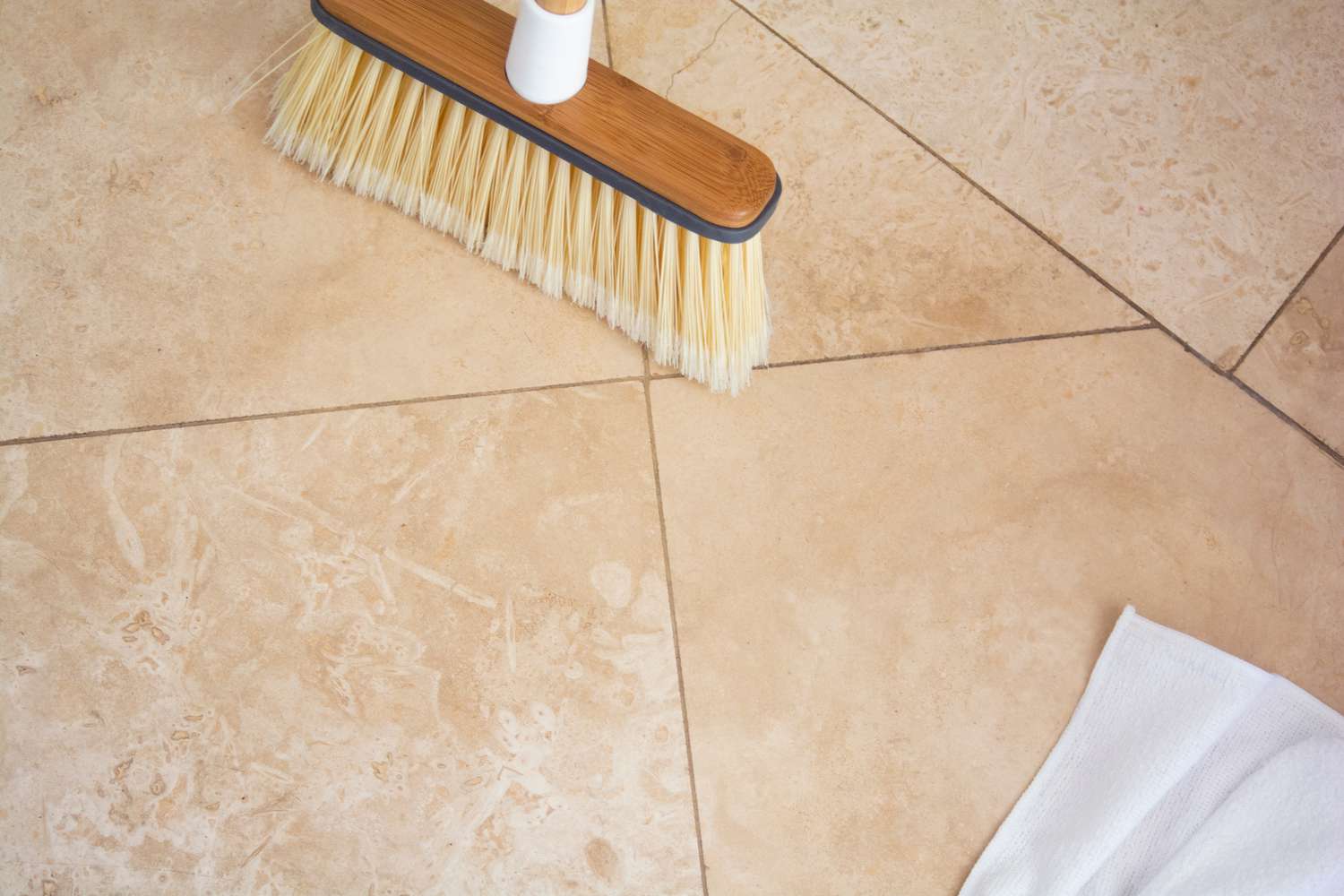 Carrelage en pierre travertine nettoyé avec un balai et un chiffon