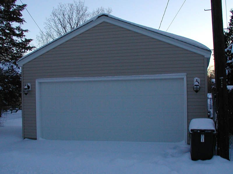 Un garage pour deux voitures recouvert de neige