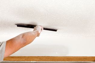 Person applying texture to a ceiling