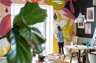 Woman painting a mural in her home