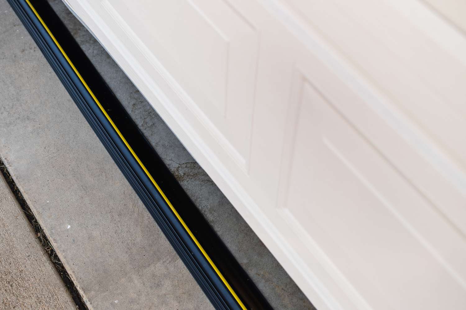 White garage door with threshold seal attached to garage floor