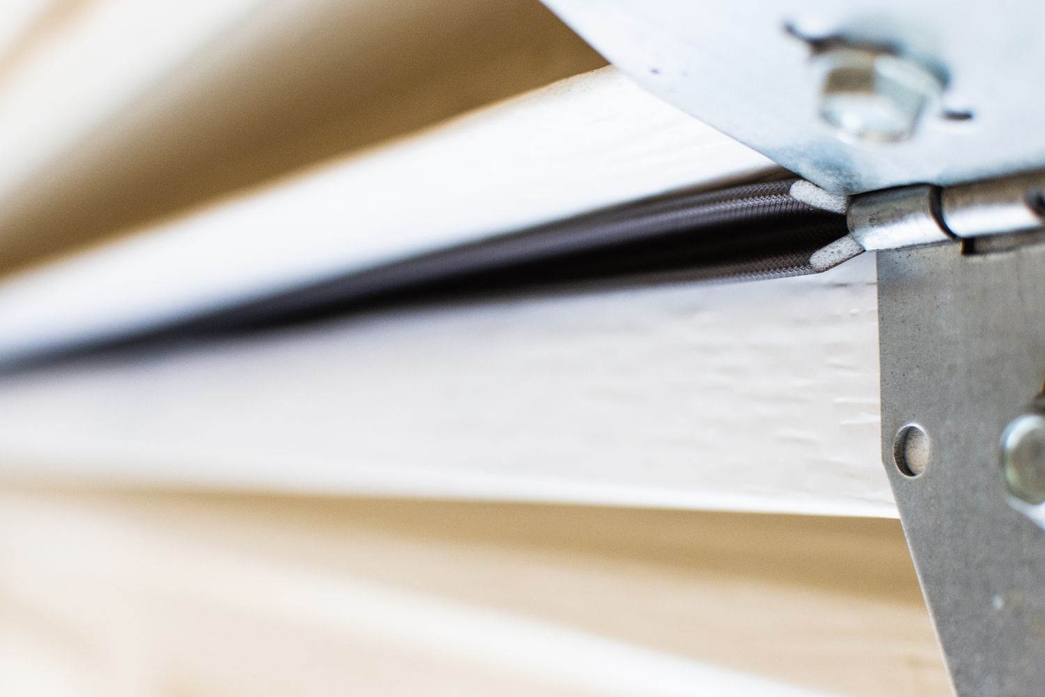 White garage door panel with v-shaped weatherstripping closeup