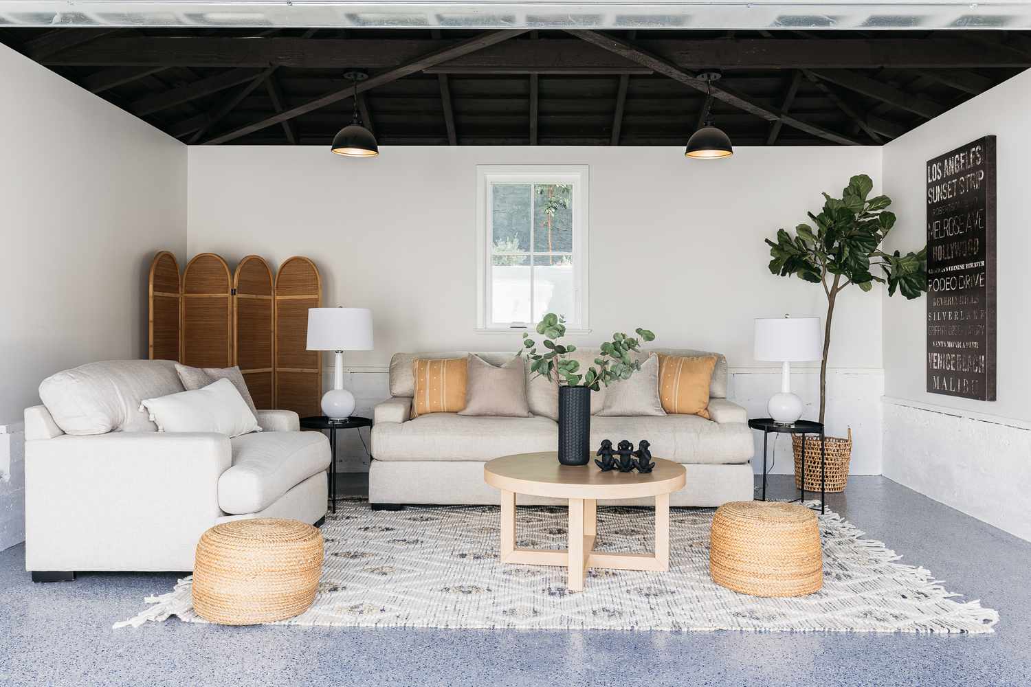 Garage makeover as a decorated living space with white couches, houseplants and neutral decor