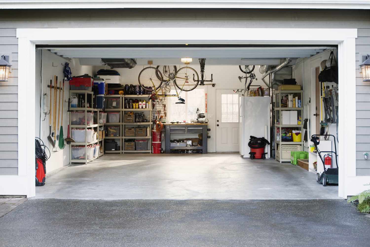 Garage de voiture propre avec étagères, outils et vélos.